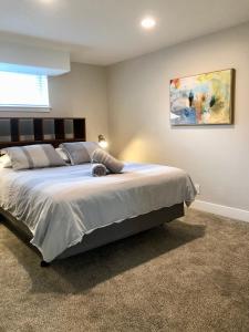 a bedroom with a large bed with a painting on the wall at Cozy Getaway near SLC Airport & Downtown - 1st floor Apartment in Salt Lake City