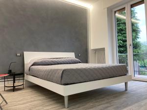 - une chambre avec un lit et une grande fenêtre dans l'établissement Garda Art&Lake, à Peschiera del Garda