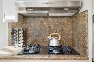 a tea kettle on top of a stove in a kitchen at Mid Century Garden View Home Parking in San Mateo