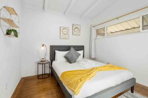 um quarto com uma cama com um cobertor amarelo em Mid Century Garden View Home Parking em San Mateo
