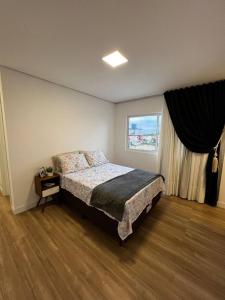En eller flere senge i et værelse på Ap Gold Coast Vista Mar - Piçarras - SC