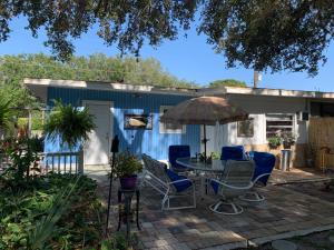 eine Terrasse mit einem Tisch, Stühlen und einem Sonnenschirm in der Unterkunft Mini Studio: 10 min/Siesta Key/Private entrance/ in Sarasota