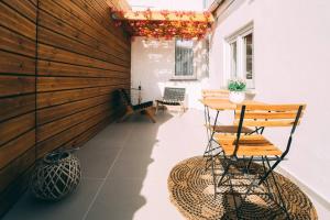 een patio met een tafel en stoelen en een vaas bij Zenansa spa privatif in Quaregnon