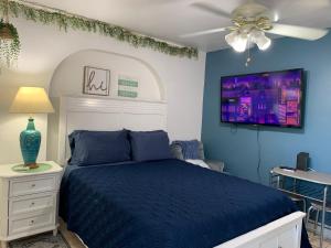 a bedroom with a blue bed and a ceiling fan at Mini Studio: 10 min/Siesta Key/Private entrance/ in Sarasota