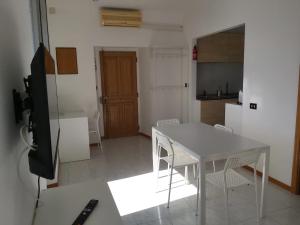 cocina con mesa blanca y sillas en una habitación en La casa di Giada&Gaia, en Recco