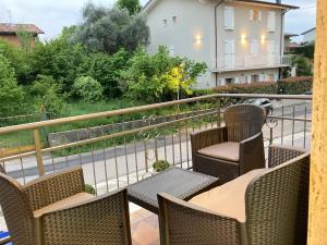 d'un balcon avec des chaises en osier et une table. dans l'établissement Garda Art&Lake, à Peschiera del Garda