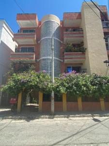 a building with a bunch of flowers in front of it at Apartamento a 2 cuadras de la playa Rodadero in Rodadero