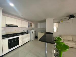 a kitchen with white cabinets and a black counter top at Apartamento a 2 cuadras de la playa Rodadero in Rodadero