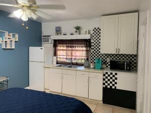a kitchen with white cabinets and a black and white checkered wall at Mini Studio: 10 min/Siesta Key/Private entrance/ in Sarasota
