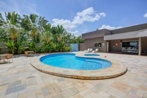 a swimming pool with a patio and a house at Quality Hotel Jundiaí in Jundiaí