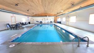 a large swimming pool with blue water in a building at Jasper Ridge Inn Ishpeming in Ishpeming