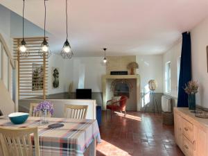 uma sala de jantar e sala de estar com mesa e cadeiras em Le gîte du four à pain em Noyers-sur-Cher