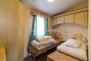 a bedroom with two beds and a window at 6 Berth Dog Friendly Caravan In Hunstanton, Minutes From The Beach Ref 13013l in Hunstanton