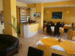 ein Restaurant mit Tischen und Stühlen und eine Bar in der Unterkunft Guest House Palme in Barbat na Rabu