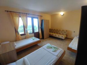 a bedroom with two beds and a window at Prostor Guest House in Byala