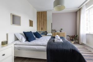 1 dormitorio con 1 cama grande con almohadas azules en Korona Starego Gdańska en Gdansk