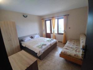 a bedroom with a large bed and a window at Prostor Guest House in Byala