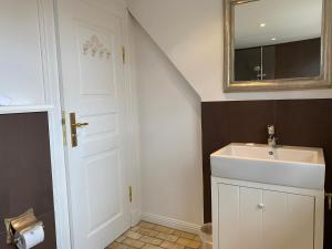 a bathroom with a sink and a mirror at HofGut Bockelkathen Apartment 3 in Lüdersburg