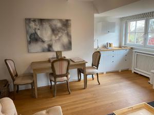 a kitchen and dining room with a table and chairs at HofGut Bockelkathen Apartment 3 in Lüdersburg