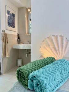 een badkamer met een groene handdoek op de vloer bij Cefalù Forest Hideout in Cefalù