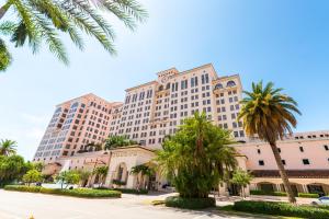 un grand hôtel avec des palmiers devant lui dans l'établissement Hyatt Regency Coral Gables in Miami, à Miami