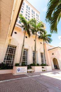 un bâtiment avec des palmiers en face de celui-ci dans l'établissement Hyatt Regency Coral Gables in Miami, à Miami
