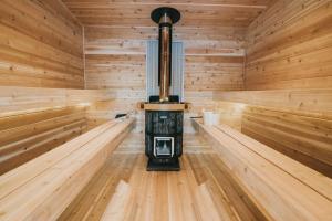 a wooden sauna with a stove in the middle at Meier Lake Resort in Wasilla