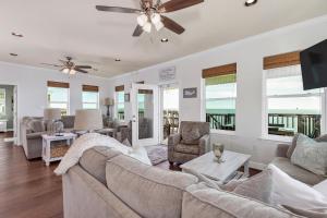 a living room with a couch and a ceiling fan at Almost Heaven in Dauphin Island
