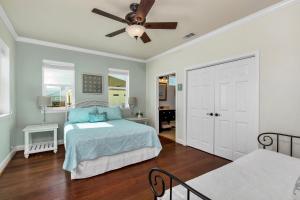 a bedroom with a bed and a ceiling fan at Almost Heaven in Dauphin Island +35 photos