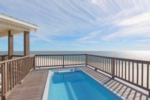 a swimming pool on a deck next to the ocean at Almost Heaven in Dauphin Island