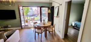 una stanza con tavolo e sedie e una camera da letto di Komfortowy Apartament Przy Bramie Targowej z tarasem- Old Town a Elblag