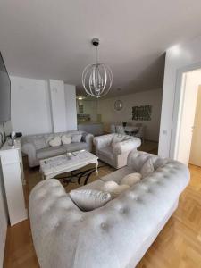 uma ampla sala de estar com sofás e um lustre em Luxury Central Apartment em Strumica