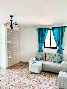 a living room with a couch and blue curtains at Apartment for 8, near to the beache and downtown in Cartagena de Indias
