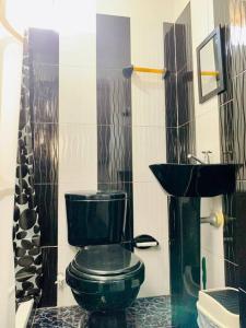 a bathroom with a black toilet and a sink at Apartment for 8, near to the beache and downtown in Cartagena de Indias