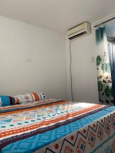 a bed with a quilt on it in a bedroom at Apartment for 8, near to the beache and downtown in Cartagena de Indias