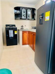 a kitchen with a stainless steel refrigerator and wooden cabinets at Apartment for 8, near to the beache and downtown in Cartagena de Indias