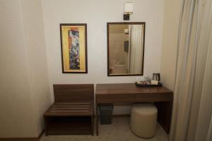 a bathroom with a wooden desk and a mirror at Family Hotel Saint George in Sofia