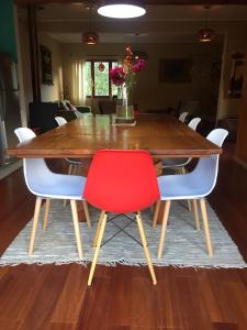 a dining room table with a red chair at Casa Río Calle Calle in Valdivia