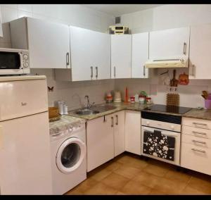 a kitchen with white cabinets and a sink and a dishwasher at Casa Daila in Costa de Antigua