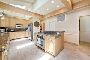 a large kitchen with wooden cabinets and stainless steel appliances at Villa Jules, Oceanfront, Private Beach, Fire Pit in Oceanside
