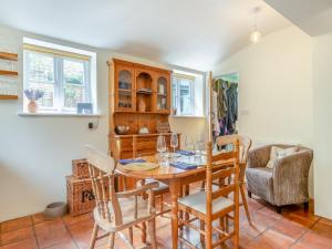 a dining room with a wooden table and chairs at Church House Cottage in East Stour