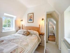 a bedroom with a bed and a window at Church House Cottage in East Stour
