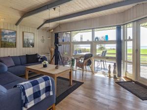 sala de estar con sofá azul y mesa en Three-Bedroom Holiday home in Øster Assels 1 en Sillerslev
