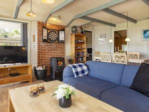 a living room with a blue couch and a table at Fjordview Retreat with Spa - By Traum Ferienwohnungen in Sillerslev