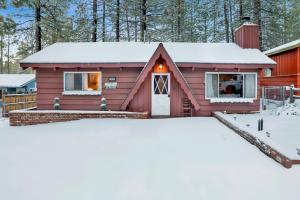 a red house with snow in front of it at Pine Cone Cottage by Big Bear Vacations Adorable Walk To Lake Furnished Chalet in Big Bear Lake +5 photos