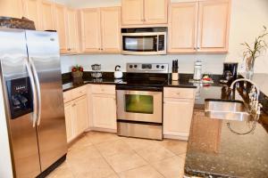 a kitchen with stainless steel appliances and white cabinets at Holiday Isle 221 in Dauphin Island