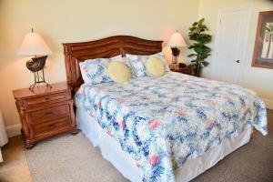 a bedroom with a bed and a nightstand with two lamps at Holiday Isle 221 in Dauphin Island