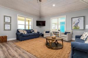 a living room with blue couches and a table at Sunny & 75 in Dauphin Island