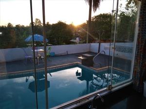 a swimming pool with the reflection of the sunset at Mi Casa, Águas de São Pedro in Águas de São Pedro