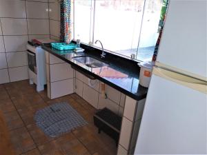 a small kitchen with a sink and a refrigerator at Mi Casa, Águas de São Pedro in Águas de São Pedro